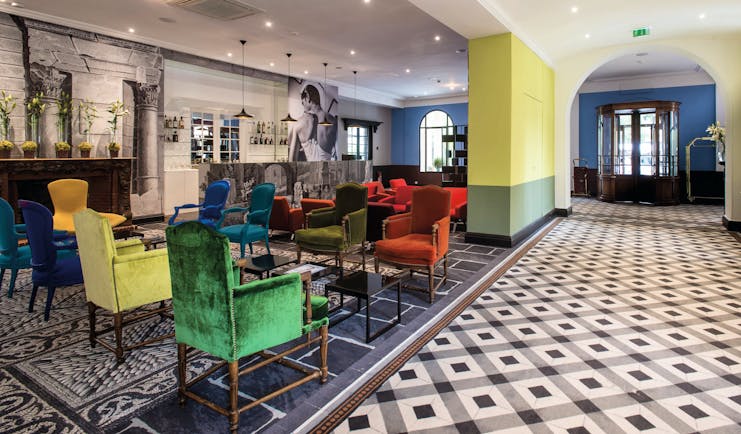 Hotel Jules Cesar Provence bar lounge tiled floor large black and white photograph and several bright chairs