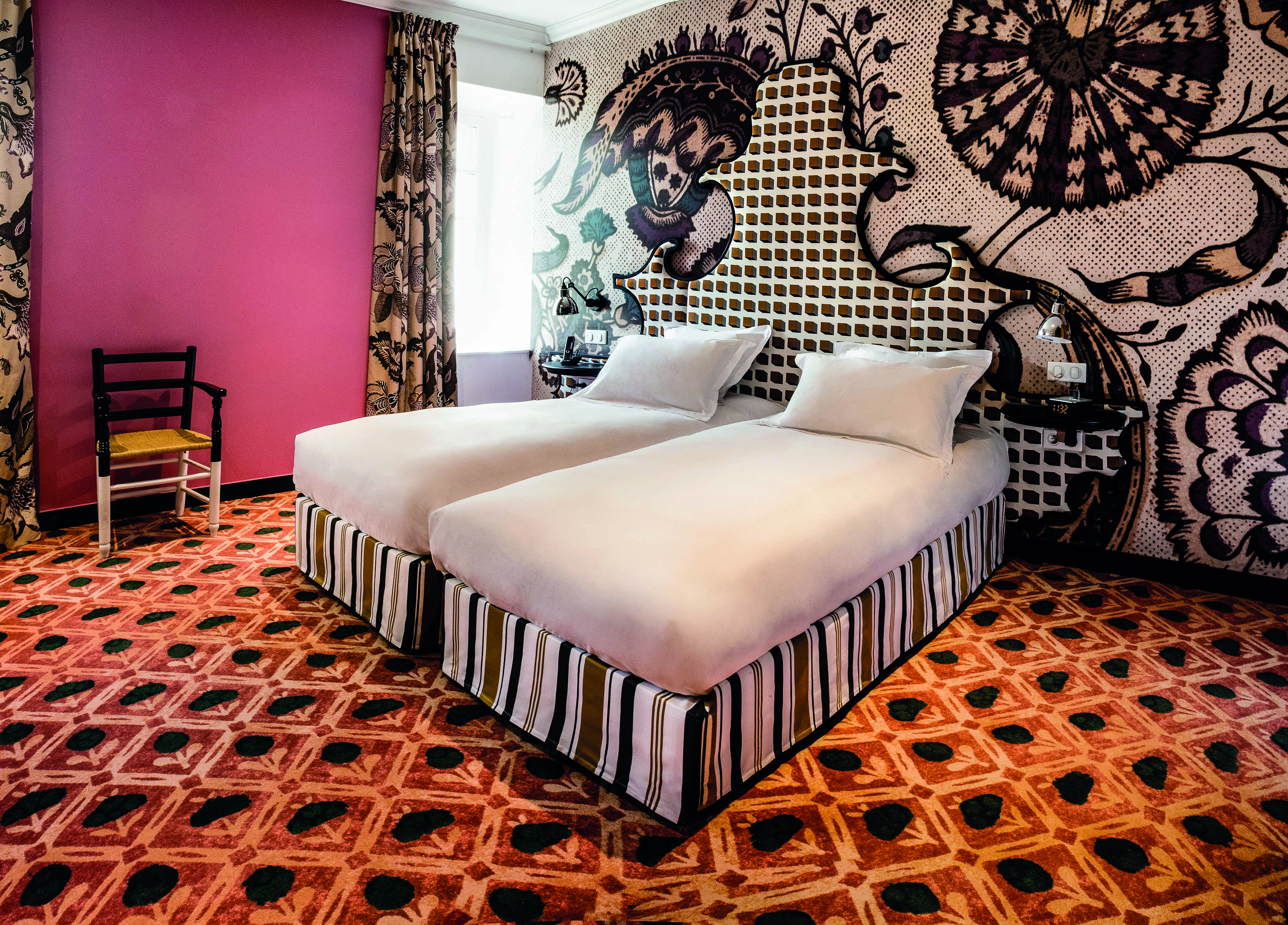 Hotel Jules Cesar Provence double bedroom with pink walls orange carpet and one wall with graphic print