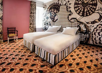 Hotel Jules Cesar Provence double bedroom with pink walls orange carpet and one wall with graphic print