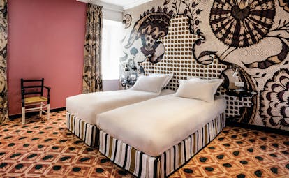 Hotel Jules Cesar Provence double bedroom with pink walls orange carpet and one wall with graphic print