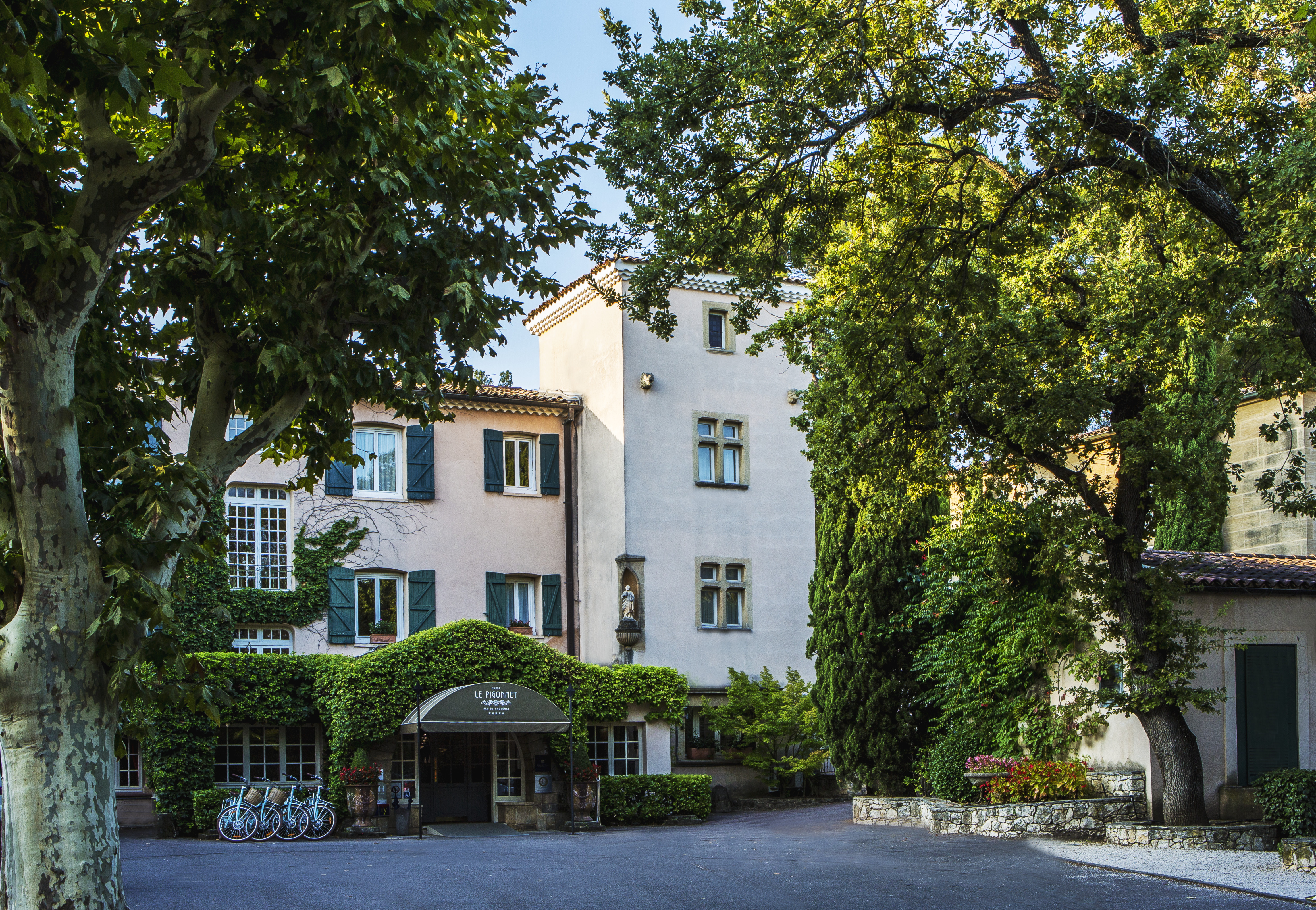 Provencal villa showing entrance to hotel with trees at le Pigonnet