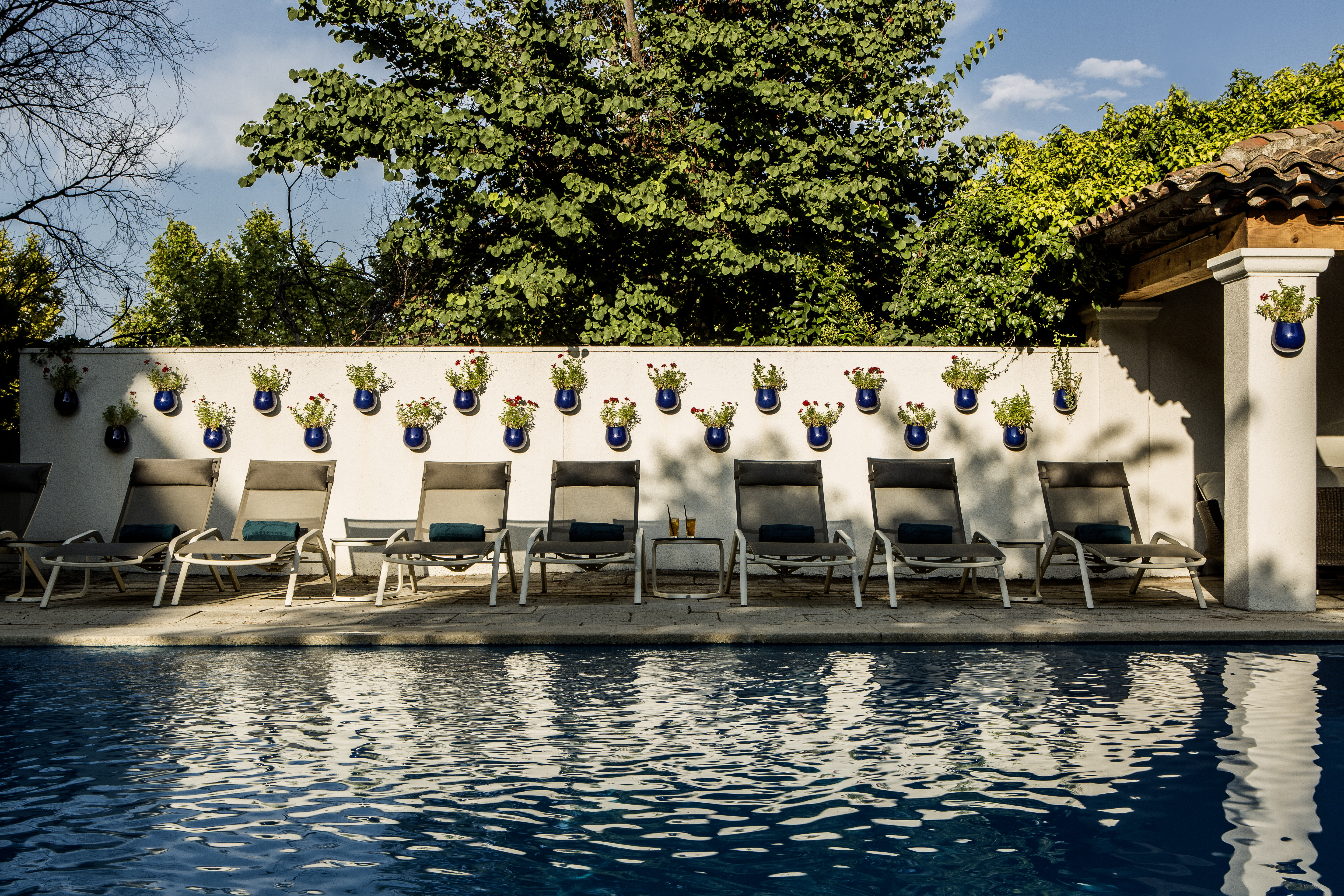 Row of sunbeds by wall next to pool at le Pigonnet