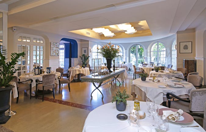 Restaurant with round white table,s wooden floor and glass windows at the pigonnet