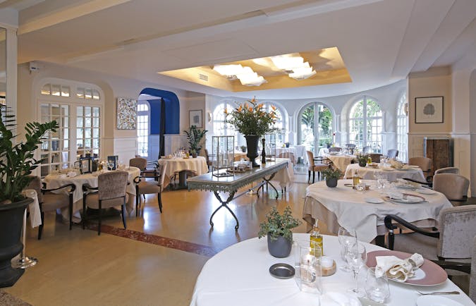 Restaurant with round white table,s wooden floor and glass windows at the pigonnet