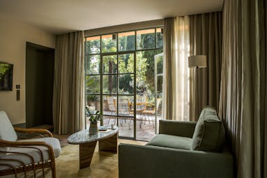 Living room of suite with green sofa and terrace at le Pigonnet