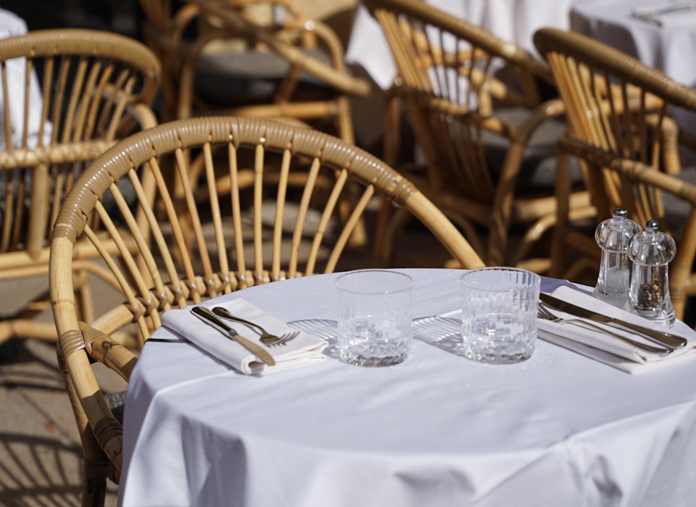 Hotel Negrecoste restaurant showing white-clothed tables with rattan chairs