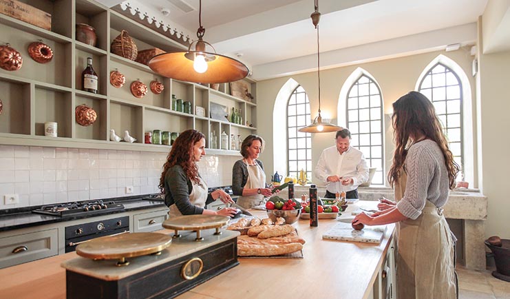 Chateau de Berne Provence cooking school three women and a man in a kitchen with bread and old fashioned weighing scales