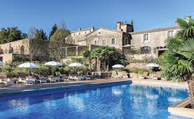 Chateau de Berne Provence exterior pool large stone building sun loungers and umbrellas