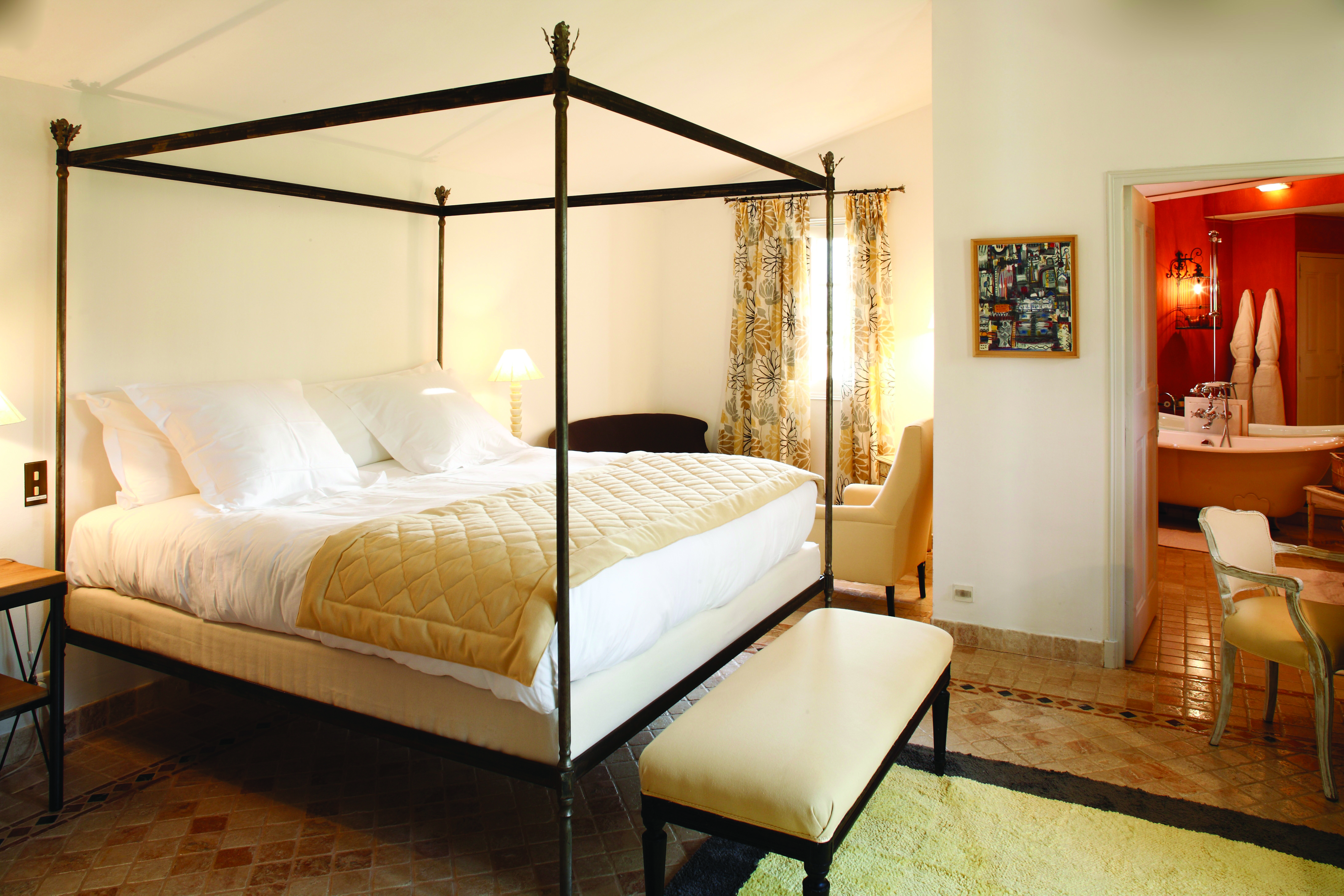 La Bastide de Moustiers Provence aviary bedroom with four poster bed view into a red bathroom
