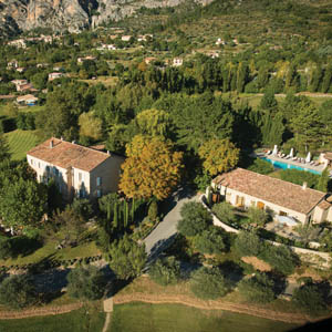 View of the hotel from above showing greenery surrounding it and swimming pool in the gardens
