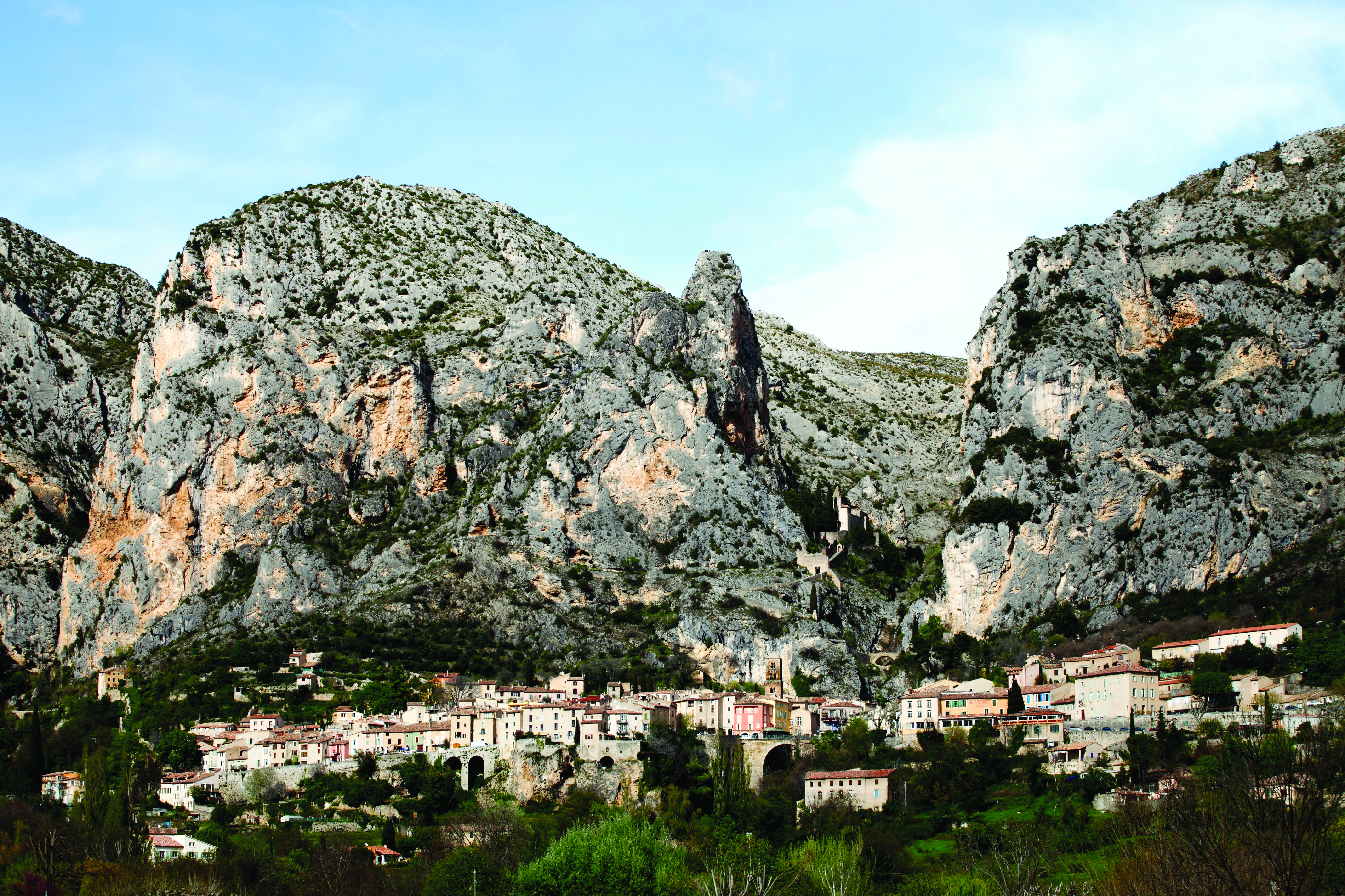La Bastide de Moustiers Provence exterior village with several houses in front of large grey rockface