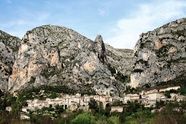 La Bastide de Moustiers Provence exterior village with several houses in front of large grey rockface