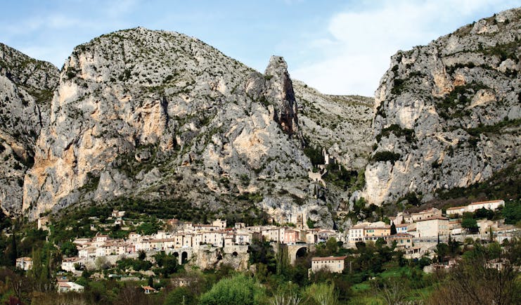 La Bastide de Moustiers Provence exterior village with several houses in front of large grey rockface