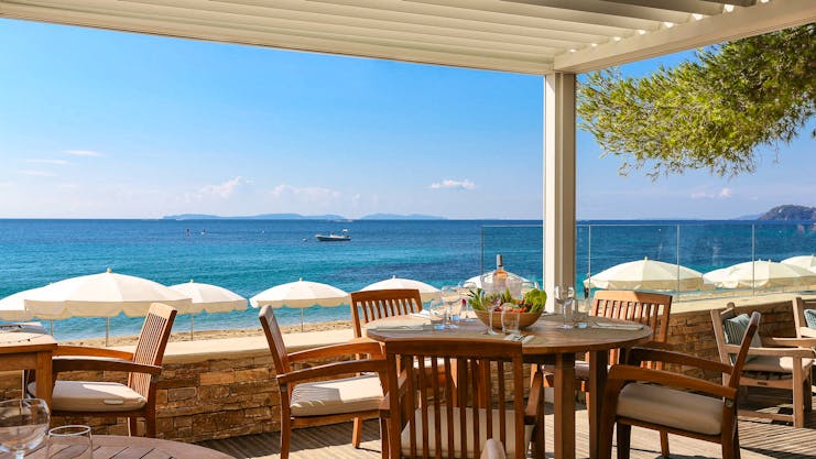 Terrace with chairs and tables over looking beach and sea at Pinede Plage