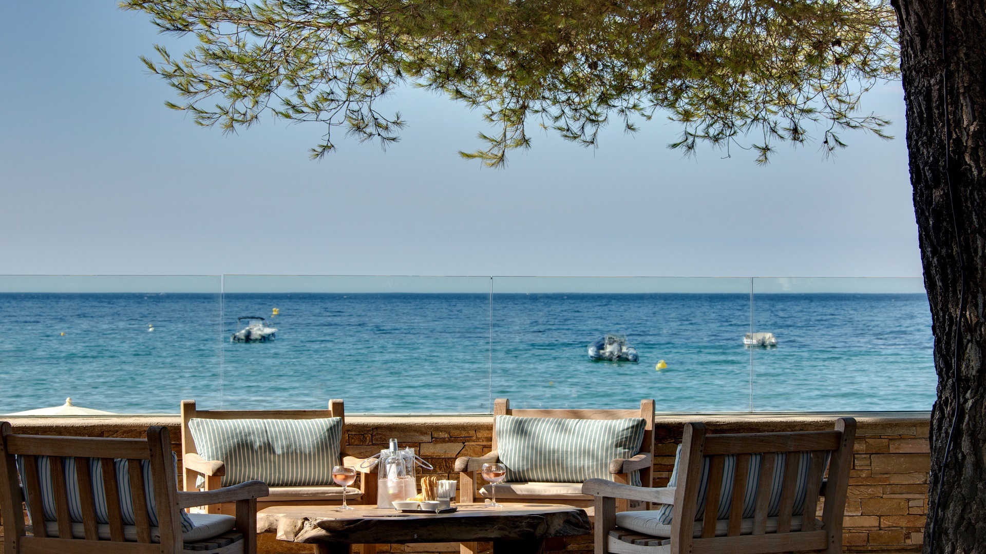 Dining terrace under tree facing the sea at Pinede Plage