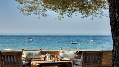Dining terrace under tree facing the sea at Pinede Plage