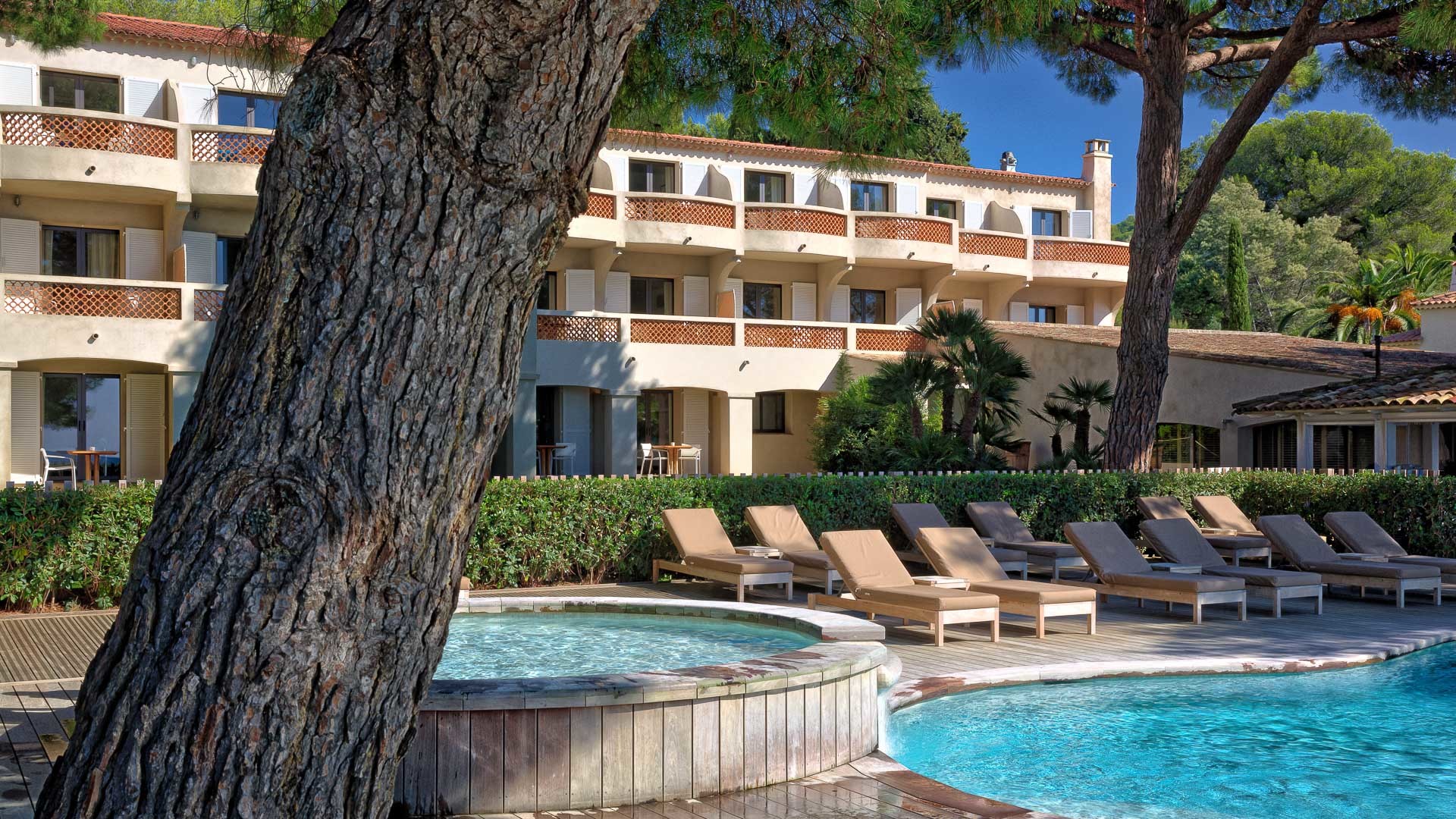 View of the low rise building with rooms and balconies in Mediterranean style overlooking pool at Pinede Plage