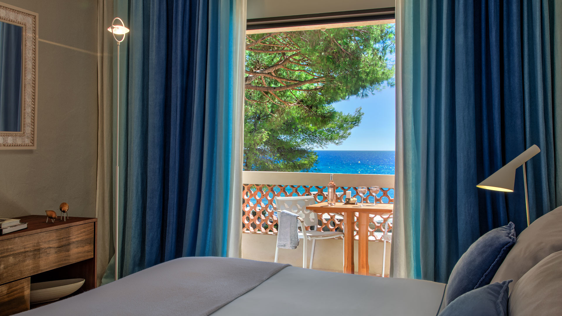 Sea facing room with balcony and blue curtains at Pinede Plage