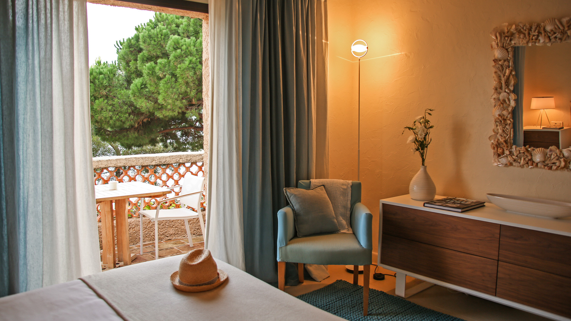 Room with white bedspread with balcony and light on at Pinede Plage