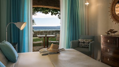 Room sea facing ground floor with terrace and blue curtains at Pinede Plage