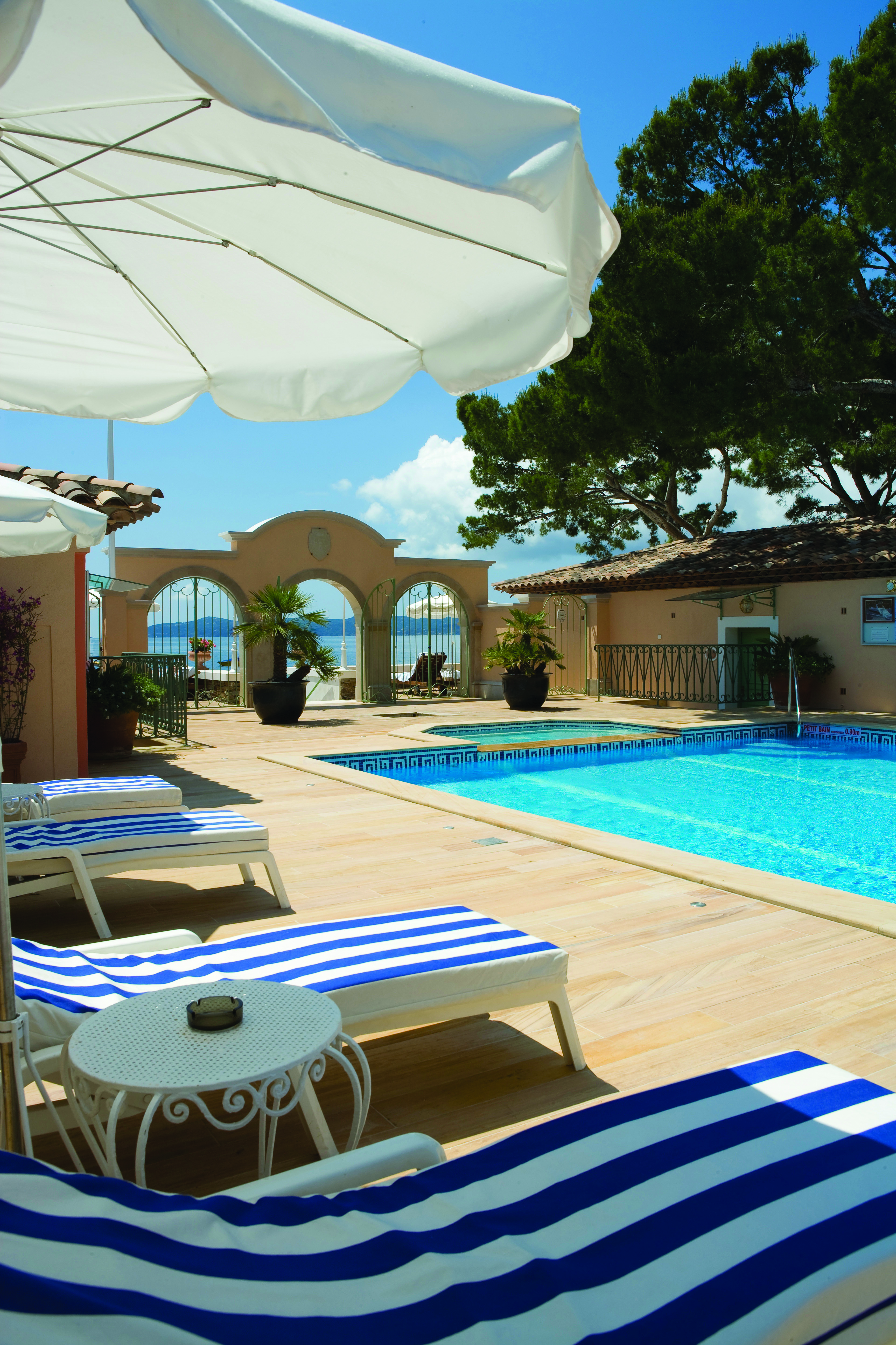 Le Club de Cavaliere Provence outdoor pool overlooking a wall with three arches and the sea