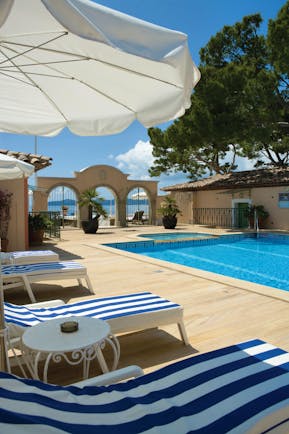 Le Club de Cavaliere Provence outdoor pool overlooking a wall with three arches and the sea