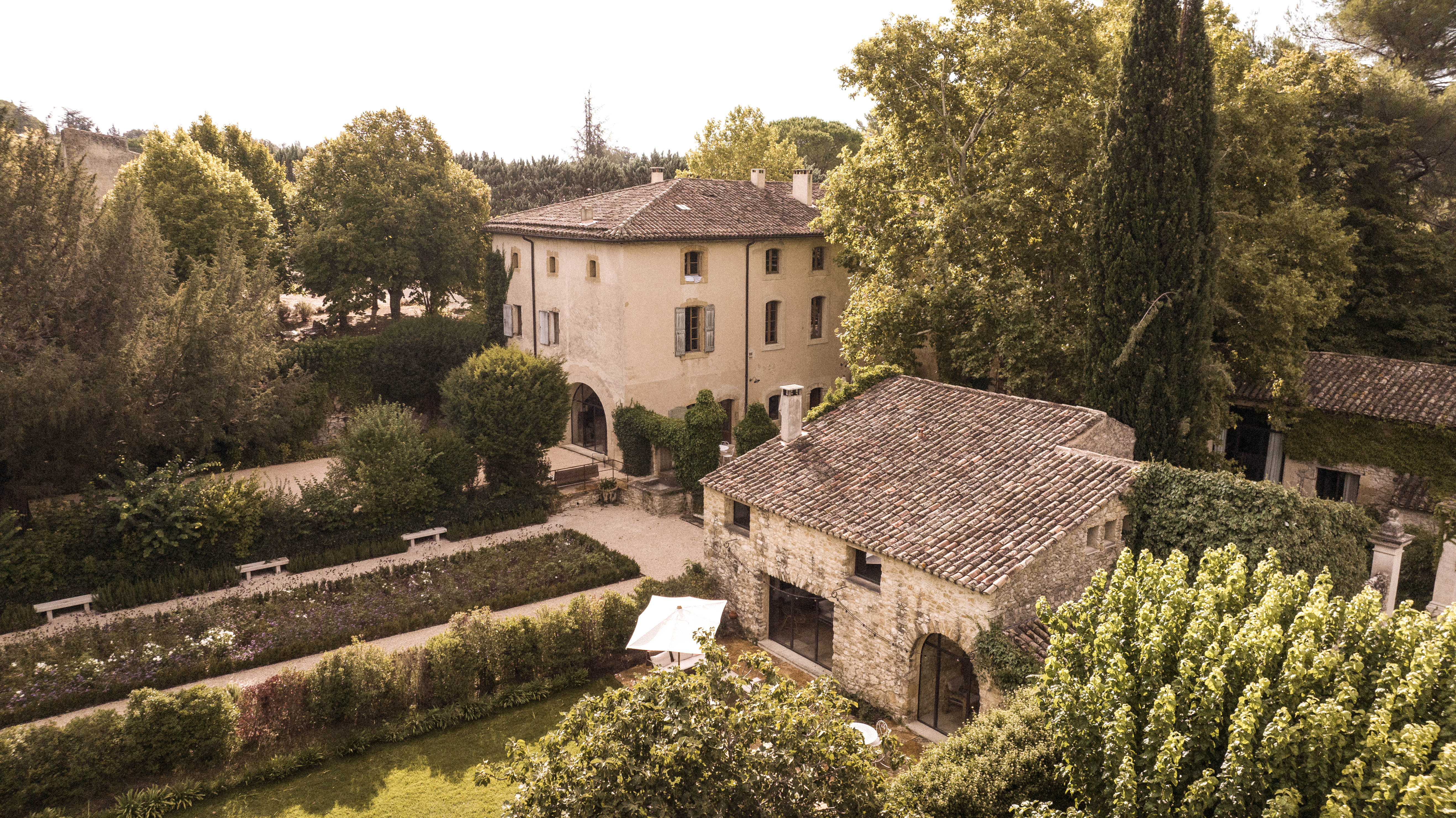 Le Galinier exterior building with stone walls, landscaped gardens, and trees