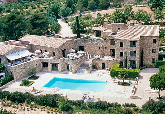Aerial view of the exterior of hotel with large pool outside 