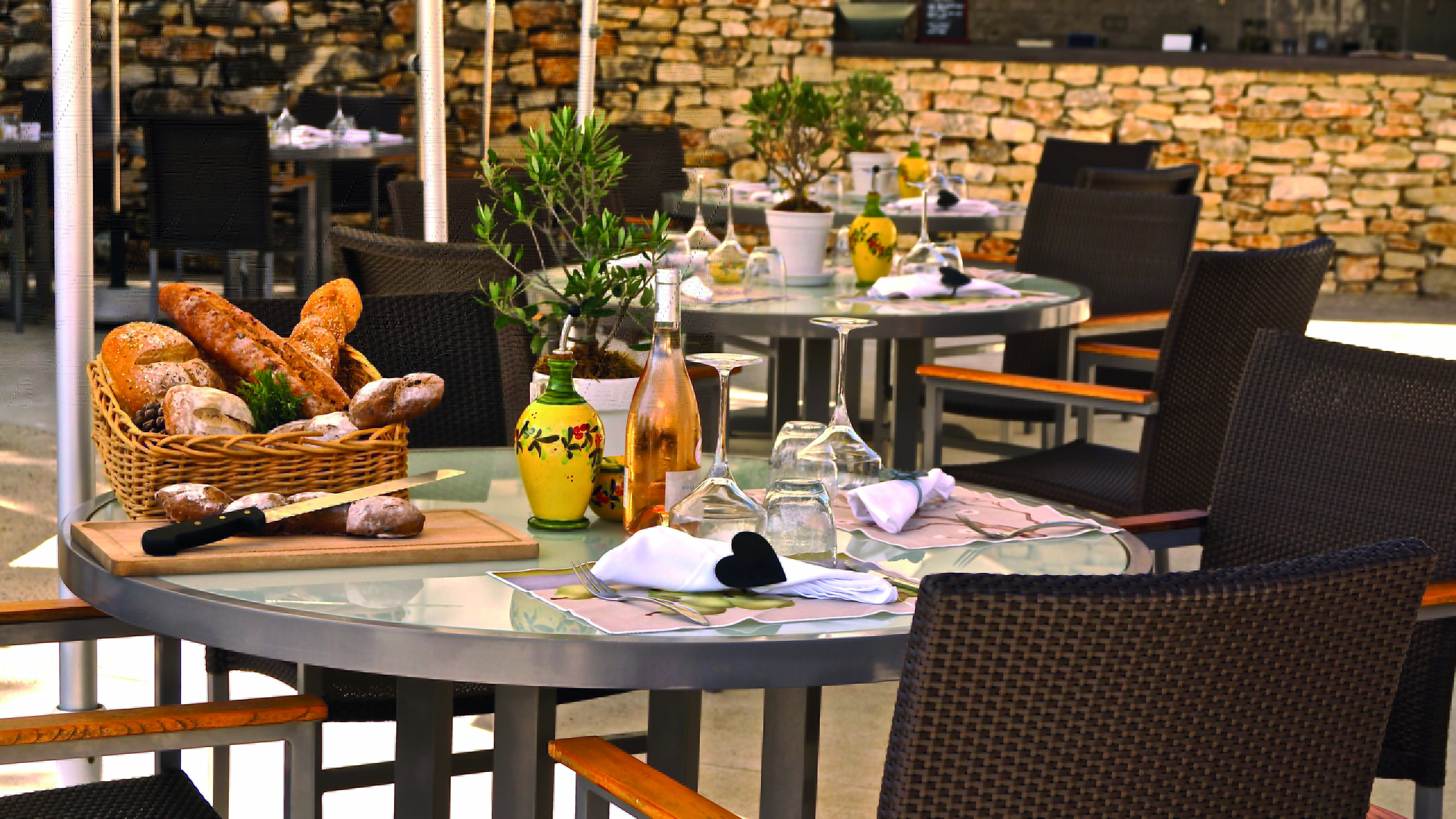 Outdoor dining area with tables set out with baskets of bread on 