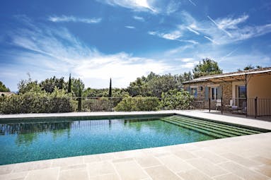 Le Phebus outdoor swimming pool with tiled surface and looking out over greenery