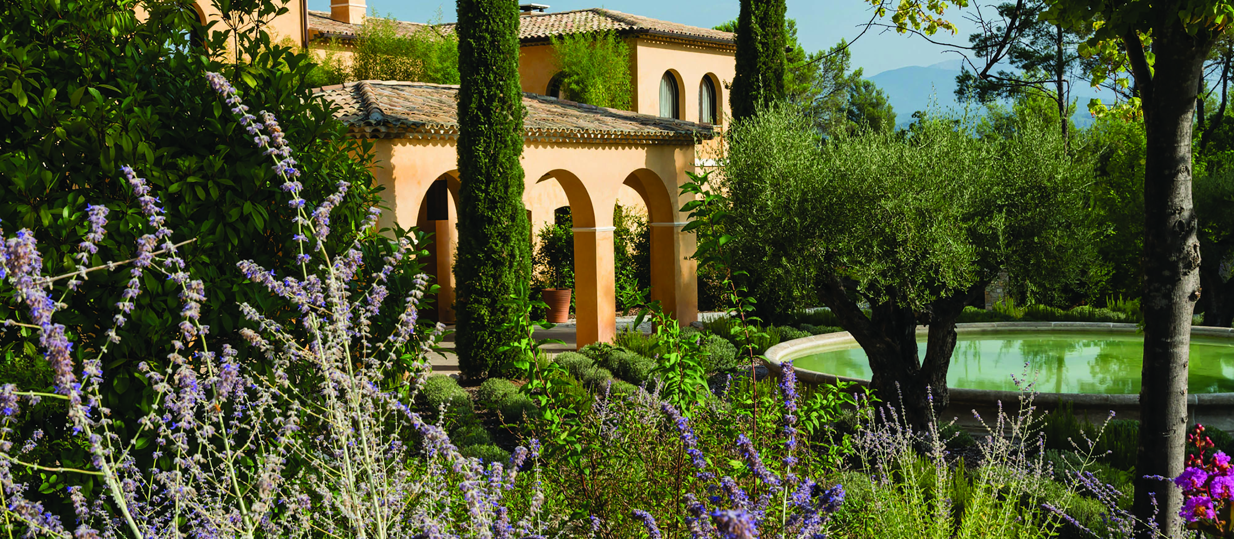 Terre Blanche Hotel and Spa Provence exterior lavender yellow building with archways pond and lavender