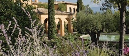Terre Blanche Hotel and Spa Provence exterior lavender yellow building with archways pond and lavender