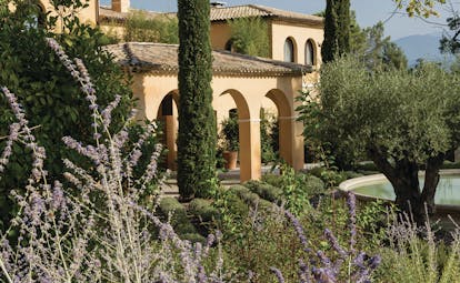 Terre Blanche Hotel and Spa Provence exterior lavender yellow building with archways pond and lavender