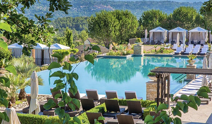 Terre Blanche Hotel and Spa Provence infinity pool with white sun loungers and cabanas