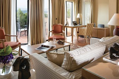 Terre Blanche Hotel and Spa Provence premier villa lounge sofa coffee table two chairs and view onto a patio