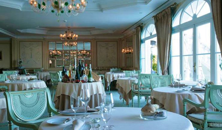 Althoff Villa Belrose Saint Tropez restaurant indoor dining area with chandeliers and large windows