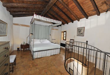 Chateau de Bagnols Rhone Valley bedroom with a four poster bed with drapes and tapestry on the wall