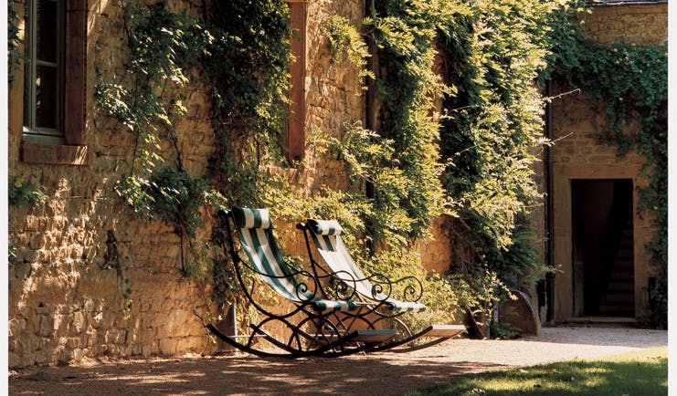 Chateau de Bagnols Rhone Valley outdoor seating two deck chairs outside wall with ivy