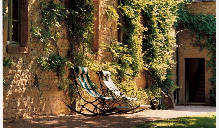 Chateau de Bagnols Rhone Valley outdoor seating two deck chairs outside wall with ivy