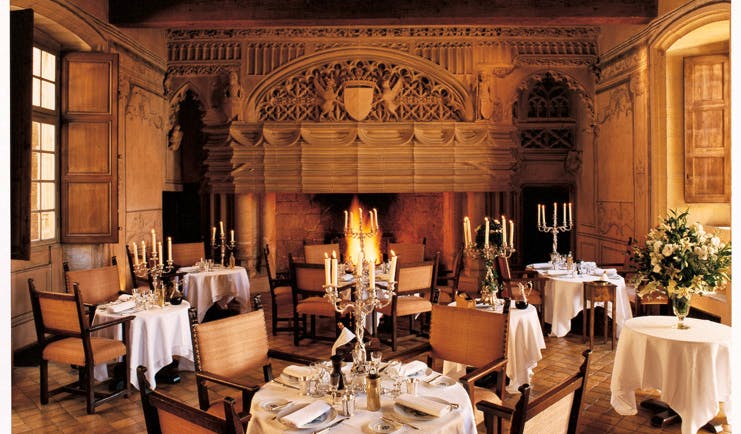 Chateau de Bagnols Rhone Valley restaurant indoor dining area with fireplace and candelabras