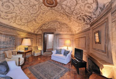 Chateau de Bagnols Rhone Valley suite lounge area with painted ceiling sofas armchair desk and fireplace