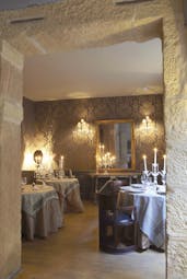 Hotel Cour des Loges Lyon dining area with three round tables with candelabras and a large mirror
