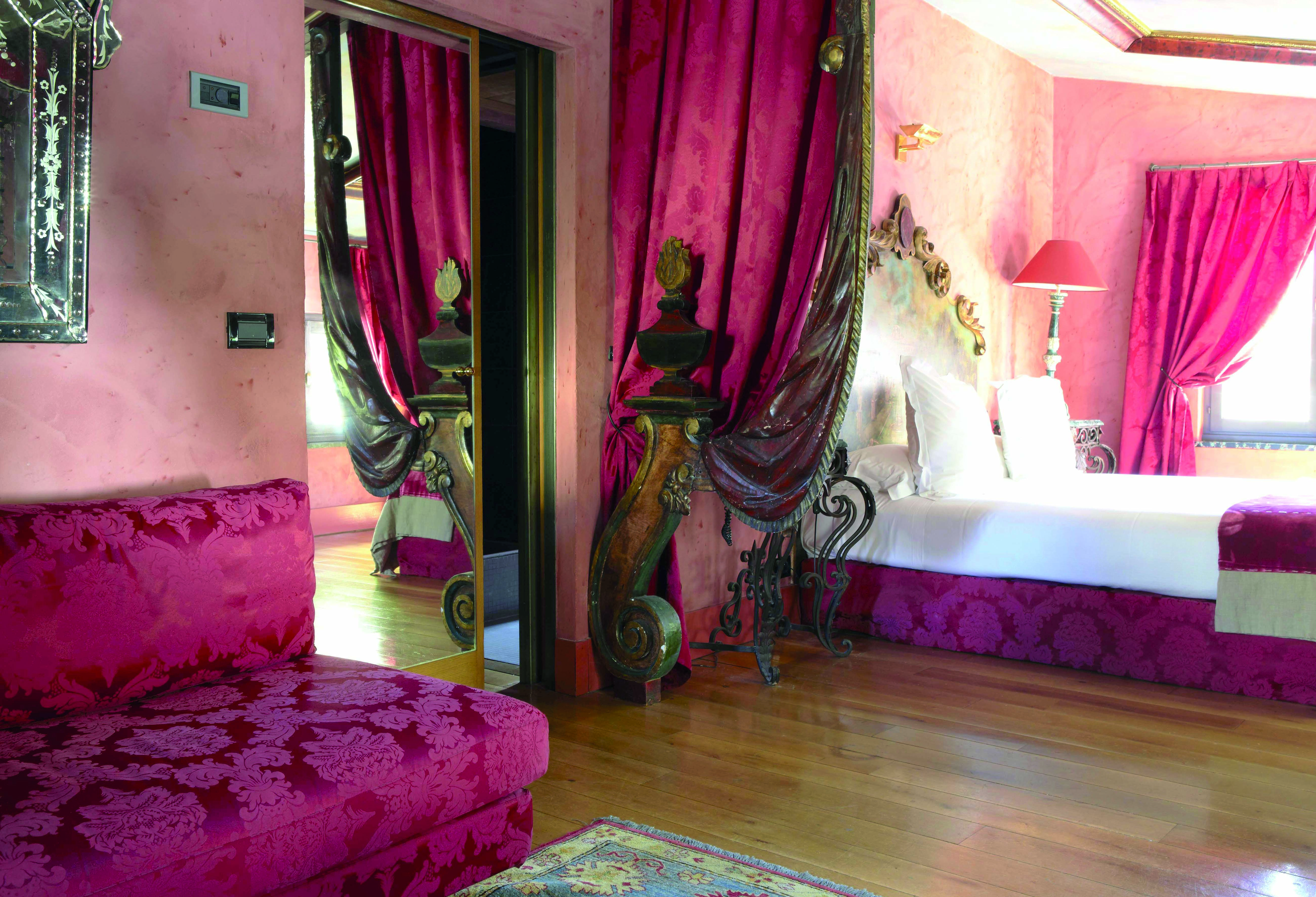Hotel Cour des Loges Lyon junior suite bedroom ornate head board red patterned sofa