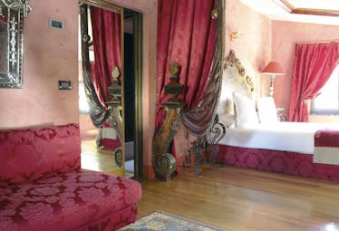 Hotel Cour des Loges Lyon junior suite bedroom ornate head board red patterned sofa