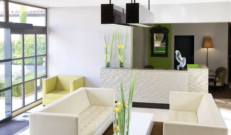 Lounge at the Hotel la Pyramide with cream coloured sofas and a green armchair