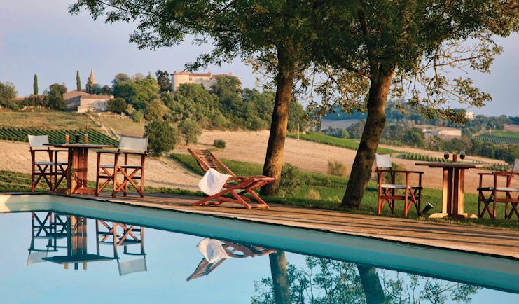 Chateau de Salettes Tarn and Lot outdoor pool overlooking fields with wooden sun loungers