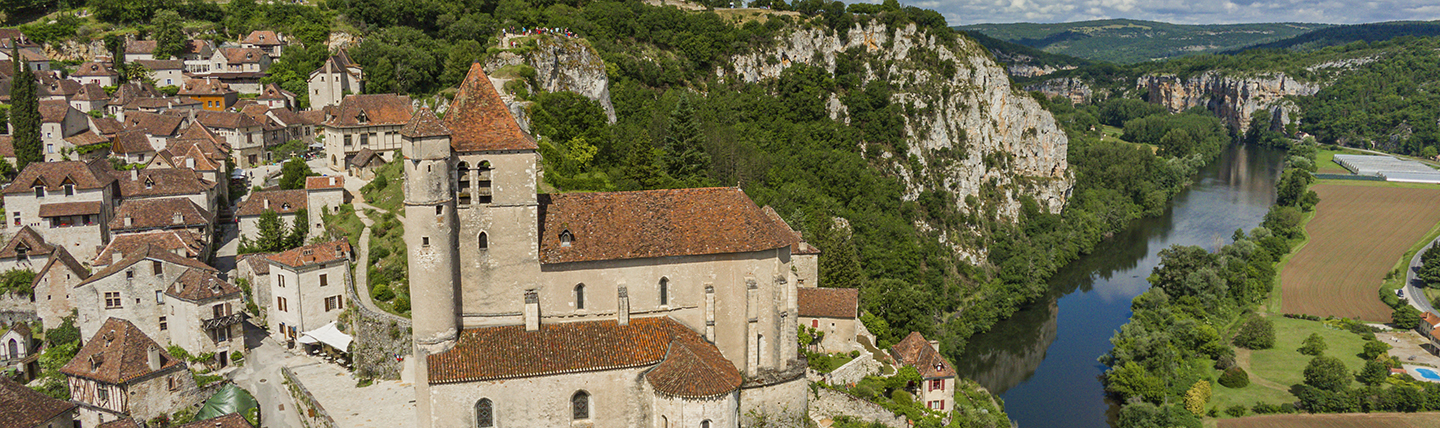 Village with brown houses on side of river valley