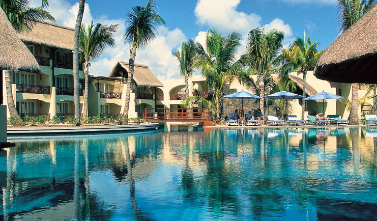 Constance Belle Mare Plage Mauritius poolside sun loungers umbrellas palm trees