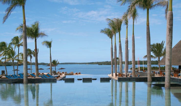 Four Seasons Mauritius infinity pool palm trees sun loungers ocean view