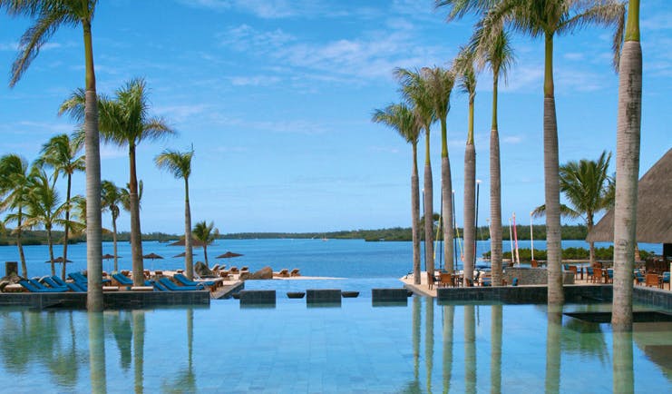 Four Seasons Mauritius infinity pool palm trees sun loungers ocean view